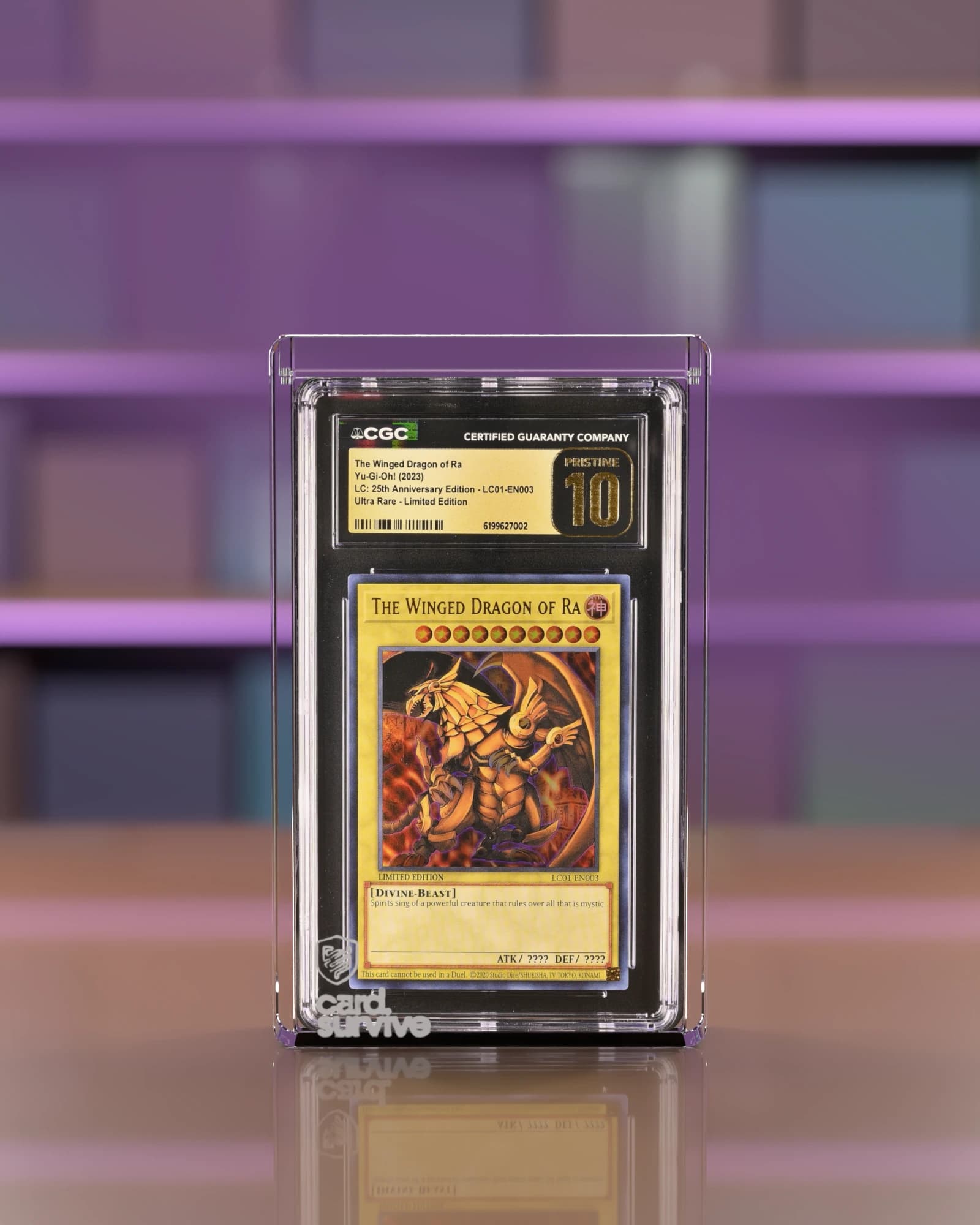 The Tank with a CGC slab of The Winged Dragon of Ra inside, front view, on a wooden counter in front of a wall of sealed booster boxes, plum light.